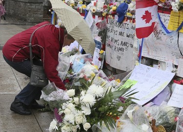 A steady stream of people stop to drop off flowers and read handwritten notes at a memorial wall at Yonge St and Finch Ave. on Wednesday April 25, 2018 after the deadly van attack in North York.Veronica Henri/Toronto Sun/Postmedia Network
