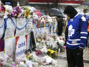 A steady stream of people stop to drop off flowers and read handwritten notes at a memorial wall at Yonge St. and Finch Ave. on Wednesday, April 25, 2018 after the deadly van attack in North York. Veronica Henri/Toronto Sun