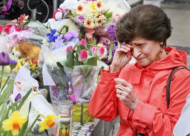 A steady stream of people stop to drop off flowers and read handwritten notes at a memorial wall at Yonge St and Finch Ave. on Wednesday April 25, 2018 after the deadly van attack in North York.Veronica Henri/Toronto Sun/Postmedia Network