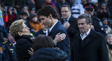 Ontario Premier Kathleen Wynne embraces Canadian Prime Minister Justin Trudeau, on the right is Toronto Mayor John Tory, before the start of the #TorontoStrong Vigil at Mel Lastman Square in Toronto, Ont. on Sunday April 29, 2018. The event brought people together following the van attack that left 10 people dead. Ernest Doroszuk/Toronto Sun/Postmedia Network