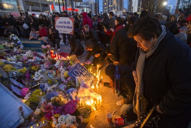Lighting candles at the memorial after the #TorontoStrong Vigil at Mel Lastman Square in Toronto, Ont. on Sunday April 29, 2018. The event brought people together following the van attack that left 10 people dead. Ernest Doroszuk/Toronto Sun/Postmedia Network