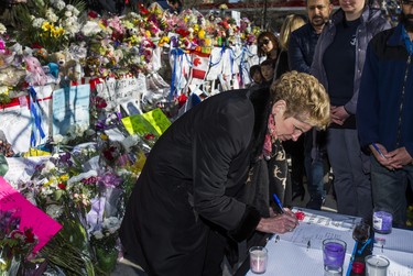 Ontario Premier Kathleen Wynne signs a book of condolence at a memorial at Olive Square - in memory of the 10 people killed in the van attack - before going to the #TorontoStrong Vigil at Mel Lastman Square in Toronto, Ont. on Sunday April 29, 2018. Ernest Doroszuk/Toronto Sun/Postmedia Network