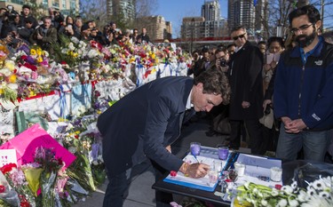 Canadian Prime Minister Justin Trudeau signs a book of condolence at a memorial at Olive Square - in memory of the 10 people killed in the van attack - before going to the #TorontoStrong Vigil at Mel Lastman Square in Toronto, Ont. on Sunday April 29, 2018. Ernest Doroszuk/Toronto Sun/Postmedia Network