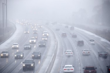 Cars drive along Toronto's Lakeshore Drive as visibility diminishes through falling hail, snow, and rain in Toronto, Ontario on Saturday, April 14, 2018. THE CANADIAN PRESS/Cole Burston