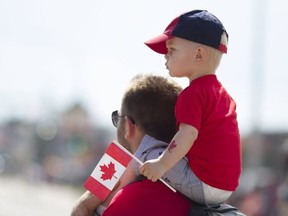 A child watches the Canada Day parade from his father's shoulders along Franklin Avenue in downtown Fort McMurray Alta. on Saturday July 1, 2017. (Robert Murray/Fort McMurray Today/Postmedia Network)