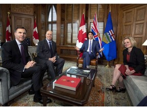 Prime Minister Justin Trudeau speaks before a meeting on the deadlock over Kinder Morgan's Trans Mountain pipeline expansion with B.C. Premier John Horgan, second from left, and Alberta Premier Rachel Notley, as Minister of Finance Bill Morneau looks on, in Trudeau's office on Parliament Hill in Ottawa on Sunday, April 15, 2018.