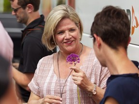 Ontario NDP leader Andrea Horwath holds a flower as she speaks Sarnia-Lambton NDP candidate Kathy Alexander during a campaign stop in Sarnia, Ontario on Wednesday, May 30, 2018. THE CANADIAN PRESS/ Geoff Robins