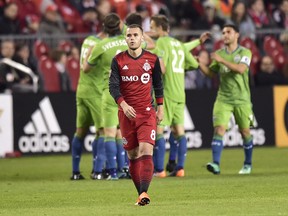 Toronto FC midfielder Ager Aketxe walks away as Seattle Sounders players celebrate their second goal on Wednesday night. (THE CANADIAN PRESS)
