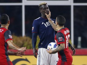 Toronto FC's Sebastian Giovinco grabs New England Revolution's Wilfried Zahibo during Saturday night's game. Giovinco received a red card for the incident. (AP PHOTO)
