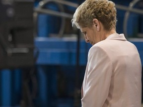 Ontario Liberal leader Kathleen Wynne stands on the podium as provincial Finance Minister Charles Sousa makes a policy announcement at the Finishing Trades Institute of Ontario in Toronto, on May 14, 2018. (THE CANADIAN PRESS)
