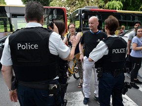 A police officer speaks with parents of children at a nearby high school in the eastern Belgian city of Liege on May 29, 2018, after a gunman shot dead three people. (AFP/GETTY IMAGES)