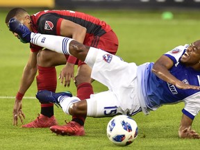 FC Dallas midfielder Jacori Hayes falls to the turf over Toronto FC's Ryan Telfer during Friday night's game. (THE CANADIAN PRESS)