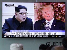 People watch a TV screen showing file footage of U.S. President Donald Trump, right, and North Korean leader Kim Jong Un during a news program at the Seoul Railway Station in Seoul, South Korea on May 26, 2018. (AP Photo/Lee Jin-man)