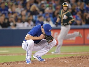 Toronto Blue Jays relief pitcher Tyler Clippard drops to the mound after giving up a grand slam to Oakland Athletics' Chad Pinder in the eighth inning of their American League MLB baseball game in Toronto on Saturday May 19, 2018. THE CANADIAN PRESS/Fred Thornhill