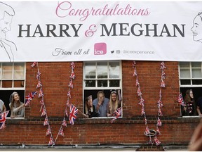 Royal fans lean out of windows as they watch Britain's Prince Harry and his best man Prince William, Duke of Cambridge, greet well-wishers on the street outside Windor Castle in Windsor on May 18, 2018, the eve of Prince Harry's royal wedding to US actress Meghan Markle.  Britain's Prince Harry and US actress Meghan Markle will marry on May 19 at St George's Chapel in Windsor Castle.