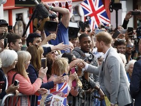 Britain's Prince Harry greets well-wishers on the street outside Windsor Castle in Windsor on May 18, 2018, the eve of Prince Harry's royal wedding to US actress Meghan Markle.  Britain's Prince Harry and US actress Meghan Markle will marry on May 19 at St George's Chapel in Windsor Castle.