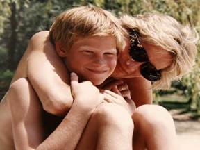An undated handout picture released by Kensington Palace from the personal photo album of the late Diana, Princess of Wales shows her embracing Prince Harry while on holiday at an undisclosed location. AFP PHOTO/KENSINGTON PALACE