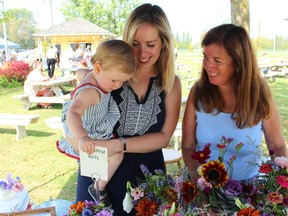 From left, Amanda Gordon of Cloverhill Flowers, her mother, Debbie Gordon, and her daughter, Lucy, at their flower booth last year.
