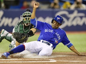 Toronto Blue Jays' Curtis Granderson, right, is tagged out at home plate by Oakland Athletics catcher Josh Phegley (19) in Toronto on Friday, May 18, 2018. (THE CANADIAN PRESS/Frank Gunn)