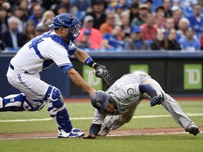 Toronto Blue Jays catcher Luke Maile tags out Seattle Mariners shortstop Jean Segura on a run down in Toronto on Wednesday May 9, 2018. (THE CANADIAN PRESS/Nathan Denette)