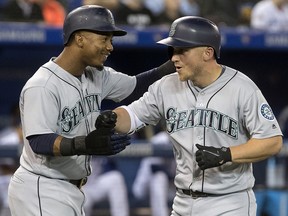 Seattle Mariners' Kyle Seager celebrates with teammate Jean Segura after hitting a grand slam against the Toronto Blue Jays Thursday May 10, 2018. (THE CANADIAN PRESS/Fred Thornhill)