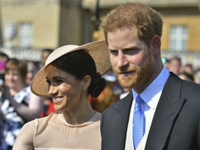 Meghan, the Duchess of Sussex walks with her husband, Prince Harry as they attend a garden party at Buckingham Palace in London, Tuesday May 22, 2018. The event is part of the celebrations to mark the 70th birthday of Prince Charles. (Dominic Lipinski/Pool Photo via AP) ORG XMIT: LON124