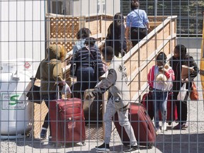 A group of asylum seekers arrive at the temporary housing facilities at the border crossing Wednesday May 9, 2018 in St. Bernard-de-Lacolle, Quebec.