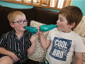 The Larocque family from Tottenham Ontario dad Jamie gets the boys, Joshua aged 5 1/2 (blue shirt) and Andre, aged 8 (R) – to blow into their “green machines” to strengthen their lungs. Both boy are fighting cystic fibrosis (CF). Andre won a “trial drug” lottery and is on a special medicine but Joshua but their parents want the government to make the lottery drugs readily available on Friday May 4, 2018. (Jack Boland/Toronto Sun)