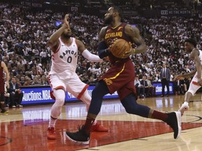 Cavaliers LeBron James (23) drives to the basket while Raptors C.J. Miles defends during third quarter NBA playoff action in Toronto on Thursday, May 3, 2018.
