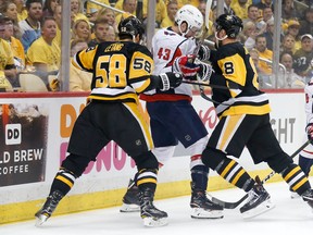 Kris Letang (58) and Brian Dumoulin of the Pittsburgh Penguins check Tom Wilson of the Washington Capitals during Game 3 of their Eastern Conference playoff series on Tuesday night. (Kirk Irwin/Getty Images)