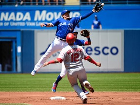 Toronto Blue Jays shortstop Giovanny Urshela can't make catch as Los Angeles Angels catcher Martin Maldonado slides during MLB action on May 24, 2018