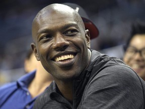 Former NFL player Terrell Owens watches the action from court side seats during the second half of a preseason NBA game between the Orlando Magic and the Memphis Grizzlies in Orlando, Fla. on Oct. 23, 2015. (AP Photo/Phelan M. Ebenhack)