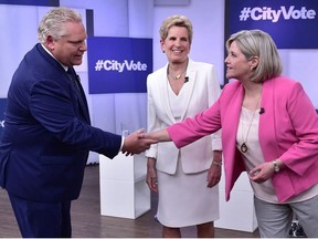 Liberal Premier Kathleen Wynne, centre, looks as Progressive Conservative Leader Doug Ford, left, and NDP Leader Andrea Horwath shake hands at the Ontario Leaders debate in Toronto on Monday, May 7, 2018. This is the first of three debates scheduled before the June 7 vote.