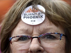 Shirley Taylor wears a "Burnt by Phoenix" sticker on her forehead during a rally against the Phoenix payroll system outside the offices of the Treasury Board of Canada in Ottawa on Wednesday, Feb. 28, 2018.
