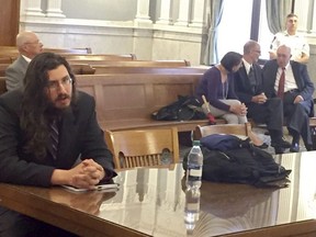 Michael Rotondo, left, sits during an eviction proceeding in Syracuse, N.Y., brought by his parents, Mark and Christina, of Camillus