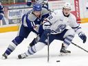 Blake McConville, left, of the Sudbury Wolves, and Keean Washkurak, of the Mississauga Steelheads, battle for the puck during OHL action at the Sudbury Community Arena in Sudbury, Ont. on Jan. 12,, 2018