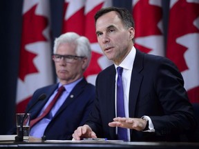 Finance Minister Bill Morneau and Natural Resources Minister James Carr speak at the National Press Theatre during a press conference in Ottawa on Tuesday, May 29, 2018.