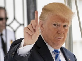 In this May 4, 2018 photo, U.S. President Donald Trump signals to the press that he will come over to talk, as he leaves the White House for Dallas to address the National Rifle Association in Washington. (AP Photo/J. Scott Applewhite)