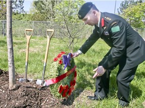 Colonel Daniel Stepaniuk CD Commander places a wreath next to a tree. School children, members from the Rotary Club veterans and currently serving members of the Canadian Armed Forces plant 500 trees at Meadowvale Rd. and Hwy. 401 on Thursday May 24, 2018. The Highway of Heroes Tree Campaign plans to plant 117,000 trees,one for every fallen Canadian soldier. (Veronica Henri/Toronto Sun)
