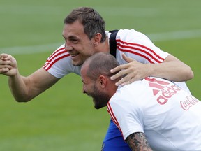 Russia's Artyom Dzyuba (left) Fyodor Kudryashov have a laugh during training on Saturday. (AP PHOTO)