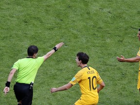 Australia's Robbie Kruse, (centre) and Andrew Nabbout react after referee Andres Cunha awarded a penalty to France on Saturday. (AP PHOTO)