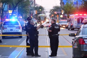 Toronto paramedics transport one of three victims of a brazen daylight shooting on Queen St. West near Peter St. just before 8 p.m. on Saturday. Two victims were rushed to hospital in life-threatening condition. Victor Biro photo