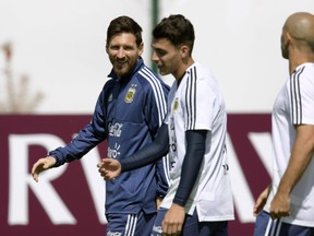 Argentina's Lionel Messi (left) walks past midfielder Cristian Pavon (centre) during a training session on Wednesday. (GETTY IMAGES)