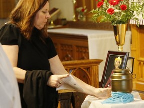 Stacey Fitzpatrick reaches for the cremation urn of her brother at the funeral of Grant "Gunner" Faulkner at St Timothy's Church in Scarborough on Monday January 26, 2015. (Michael Peake/Toronto Sun)