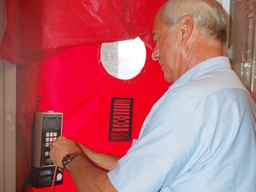 Doug Gordon sets up a blower door to test air leaks in a Cornwall home, part of the process during energy audits. (Postmedia Network)
