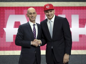Luka Doncic poses for a picture with NBA commissioner Adam Silver after being picked third overall during Thursday's draft. (AP PHOTO)