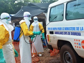 Health worker disinfect a van at the NGO Medecins Sans Frontieres (Doctors Without Borders) center in Conakry on September 13, 2014. (CELLOU BINANI/AFP/Getty Images)