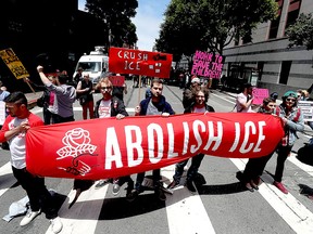 Protesters hold signs as they block Sansome St. during a demonstration outside of the San Francisco office of the Immigration and Customs Enforcement (ICE) on June 19, 2018 in San Francisco.