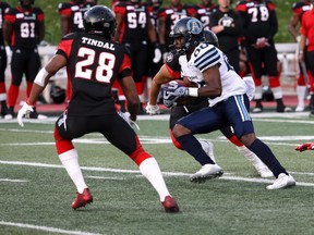 Toronto Argonauts slot back Bralon Addison snags the ball and tries to elude Ottawa Redbacks defensive back Corey Tindal during CFL pre-season action in Guelph on Thursday.(The Canadian Press)