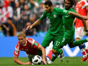 Saudi Arabia's midfielder Taisir Al-Jassim and Russia's midfielder Yuri Gazinskiy (L) vie during the Russia 2018 World Cup Group A football match between Russia and Saudi Arabia at the Luzhniki Stadium in Moscow on June 14, 2018.